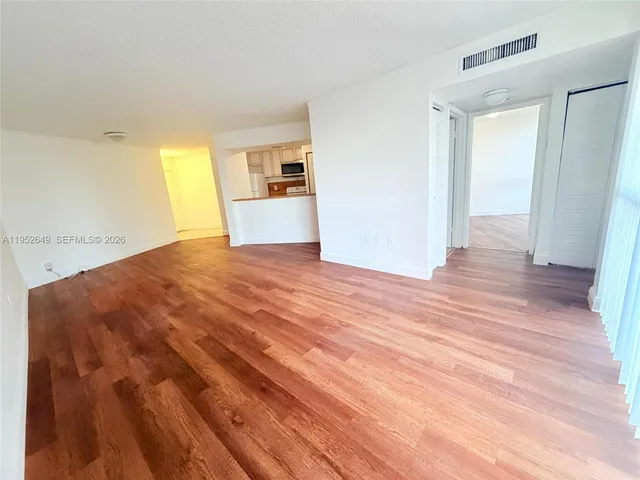 a view of empty room with wooden floor