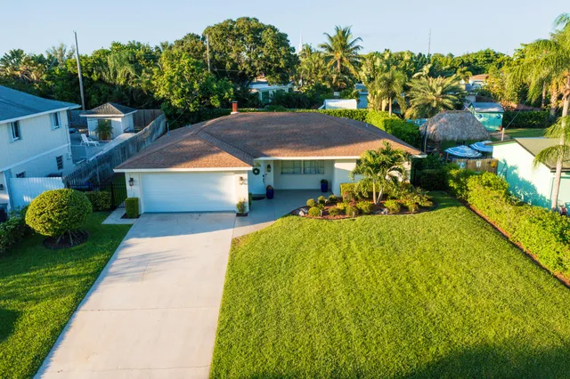 a front view of a house with a yard and trees