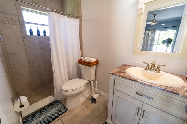 a bathroom with a granite countertop toilet sink and mirror