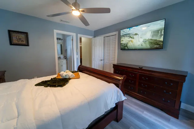 a bedroom with a bed and a flat tv screen on dresser