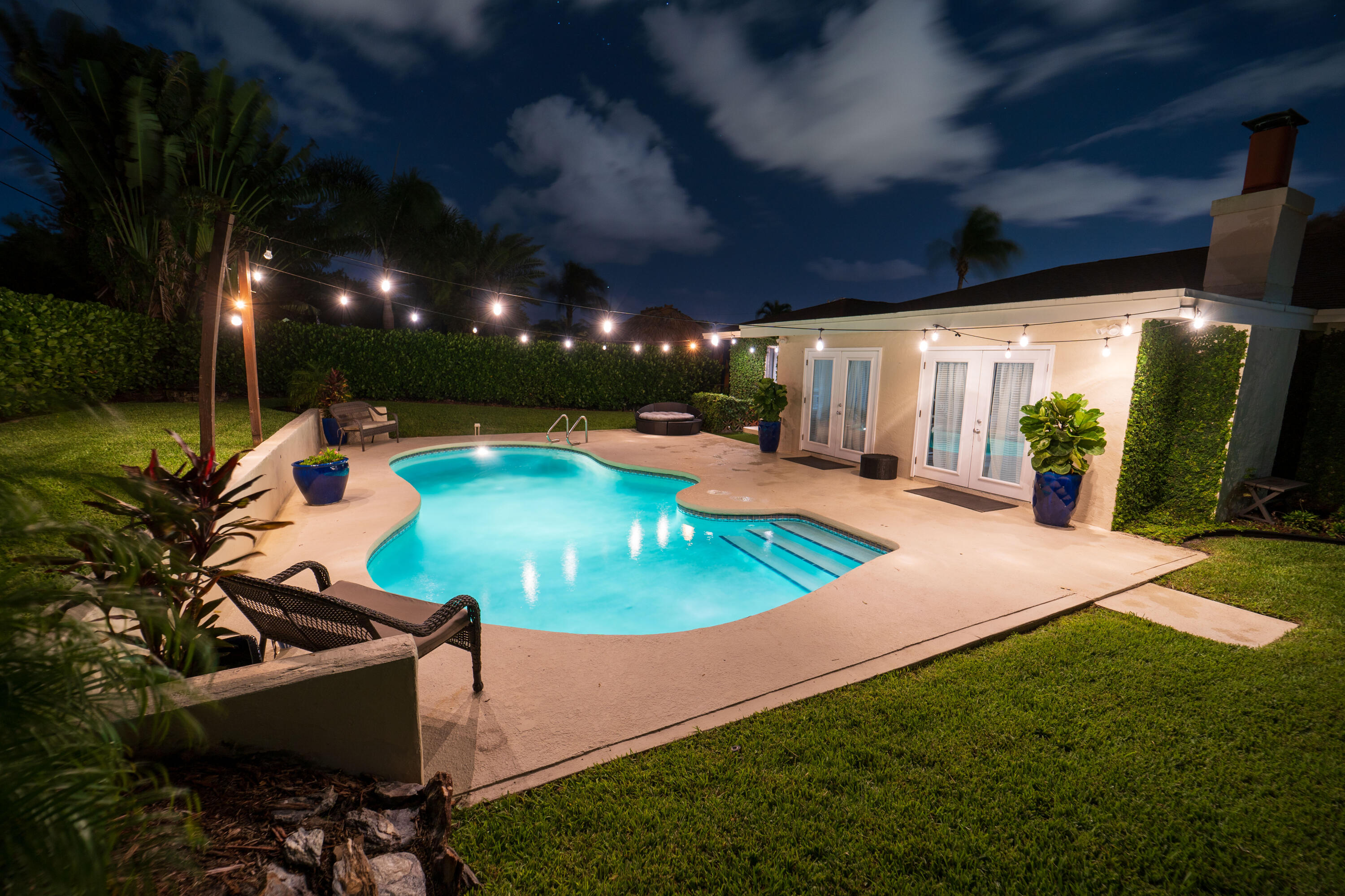Undisclosed Address Lake Worth, FL 33461 - Photo 30 of 33 a view of a swimming pool with lawn chairs under an umbrella