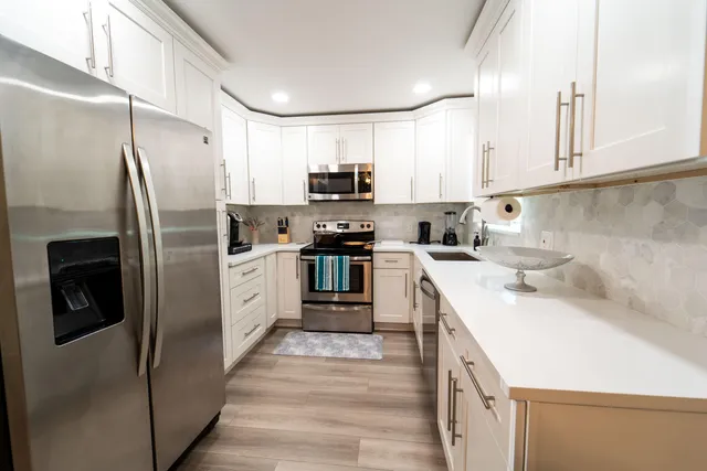 a kitchen with stainless steel appliances a refrigerator sink and microwave
