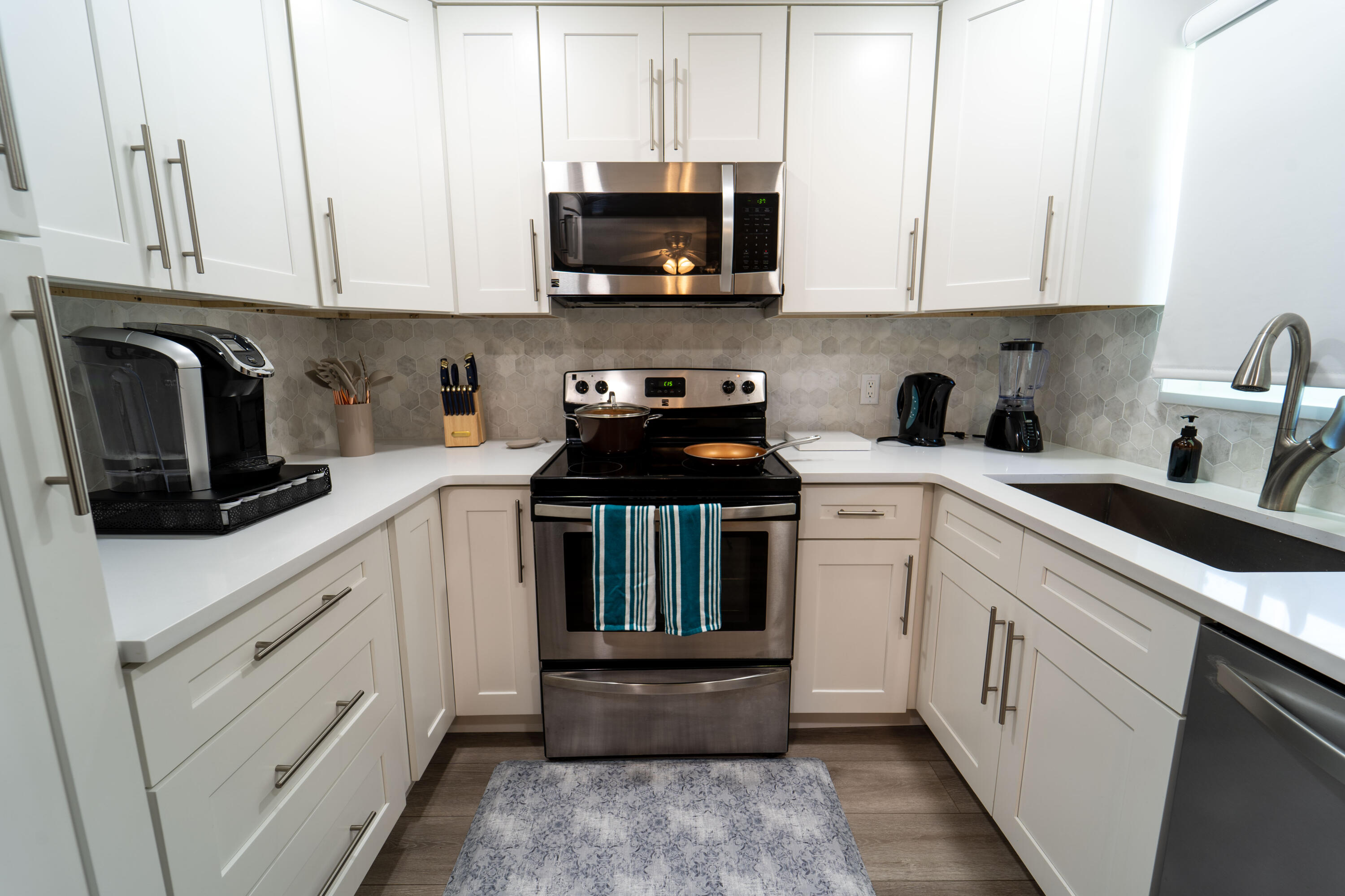 Undisclosed Address Lake Worth, FL 33461 - Photo 5 of 33 a kitchen with white cabinets and black appliances