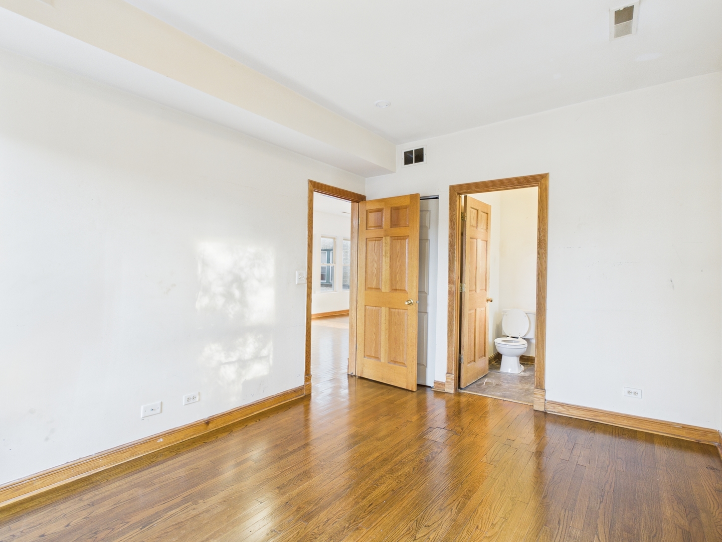 6652 South University Avenue, Unit 3B Chicago, IL 60637 - Photo 12 of 14 a view of an empty room with wooden floor and a window