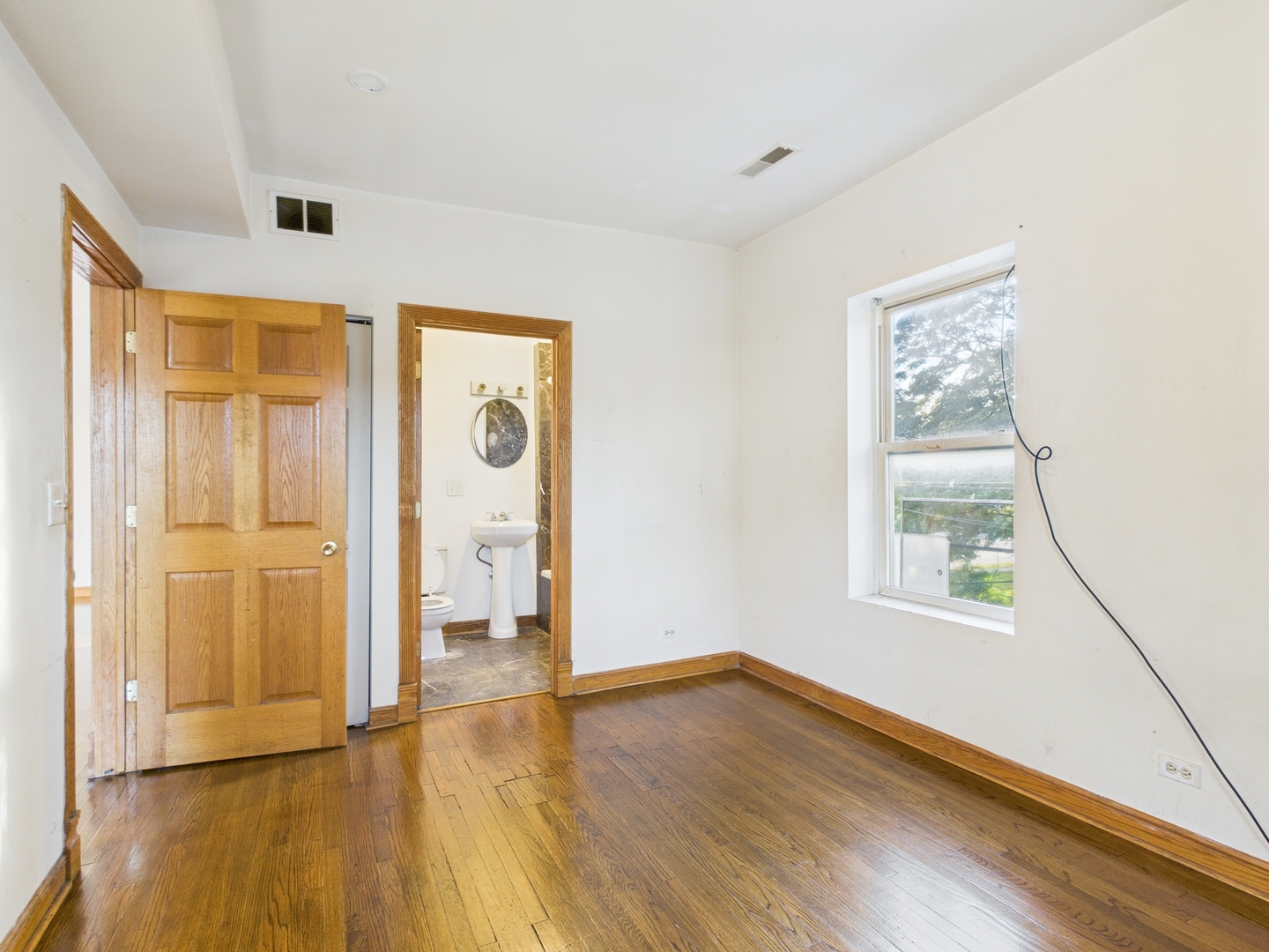 6652 South University Avenue, Unit 3B Chicago, IL 60637 - Photo 13 of 14 a view of an empty room with window and wooden floor