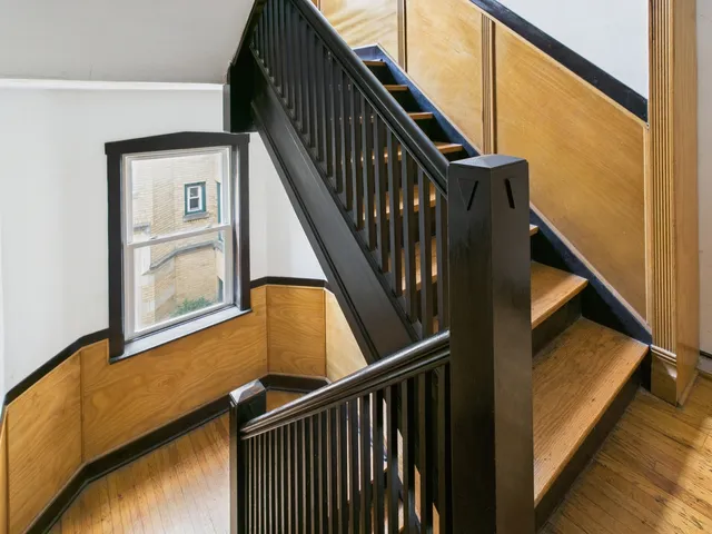 a view of staircase with wooden floor and white walls