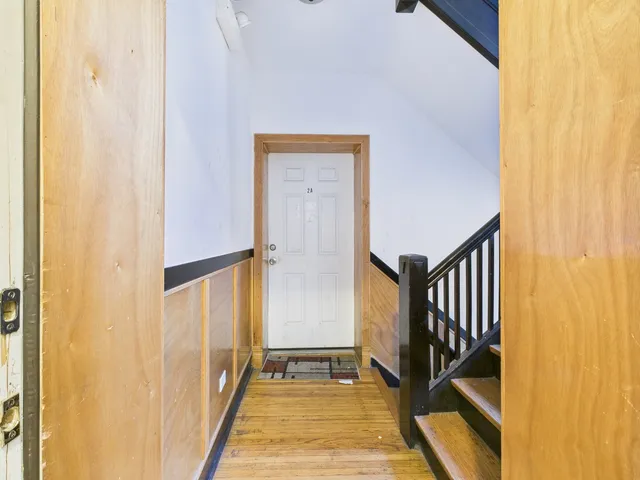 a view of a hallway with wooden floor and staircase