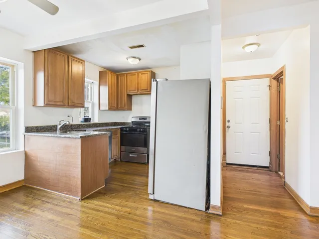 a kitchen with granite countertop wooden floors and wide window