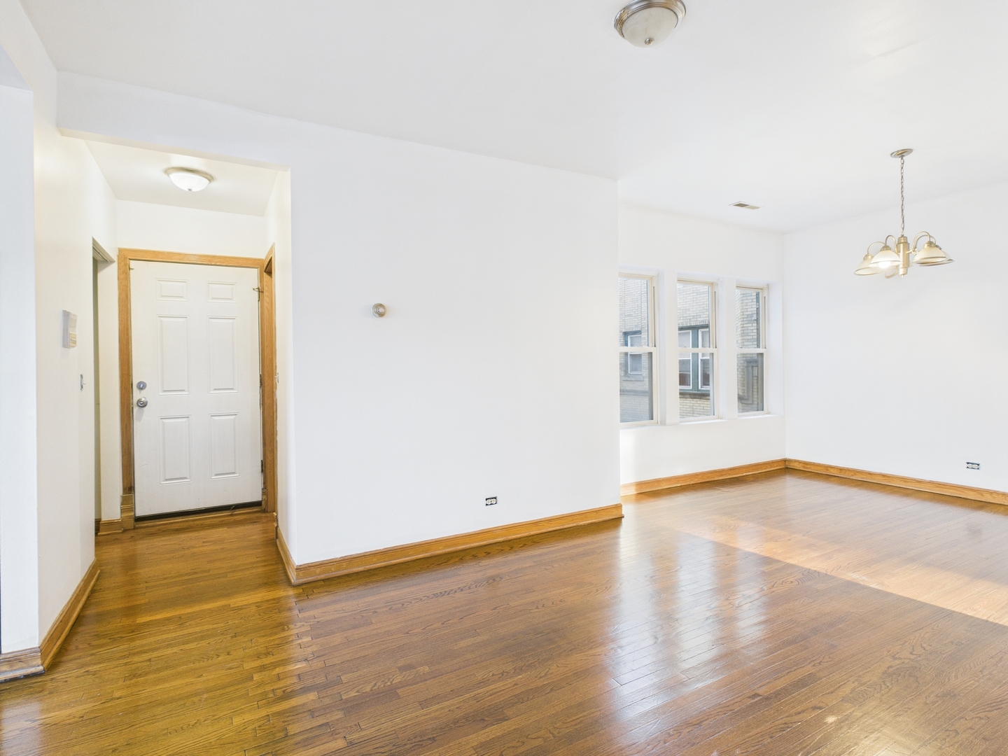 6652 South University Avenue, Unit 3B Chicago, IL 60637 - Photo 10 of 14 wooden floor in an empty room with a window