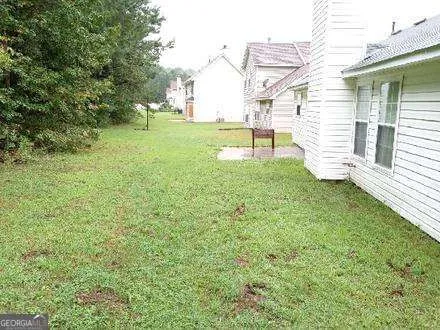 a view of a backyard with plants and a bench