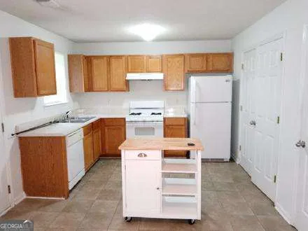 a kitchen with a cabinets and white appliances