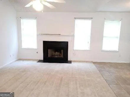 an empty room with a fireplace and windows