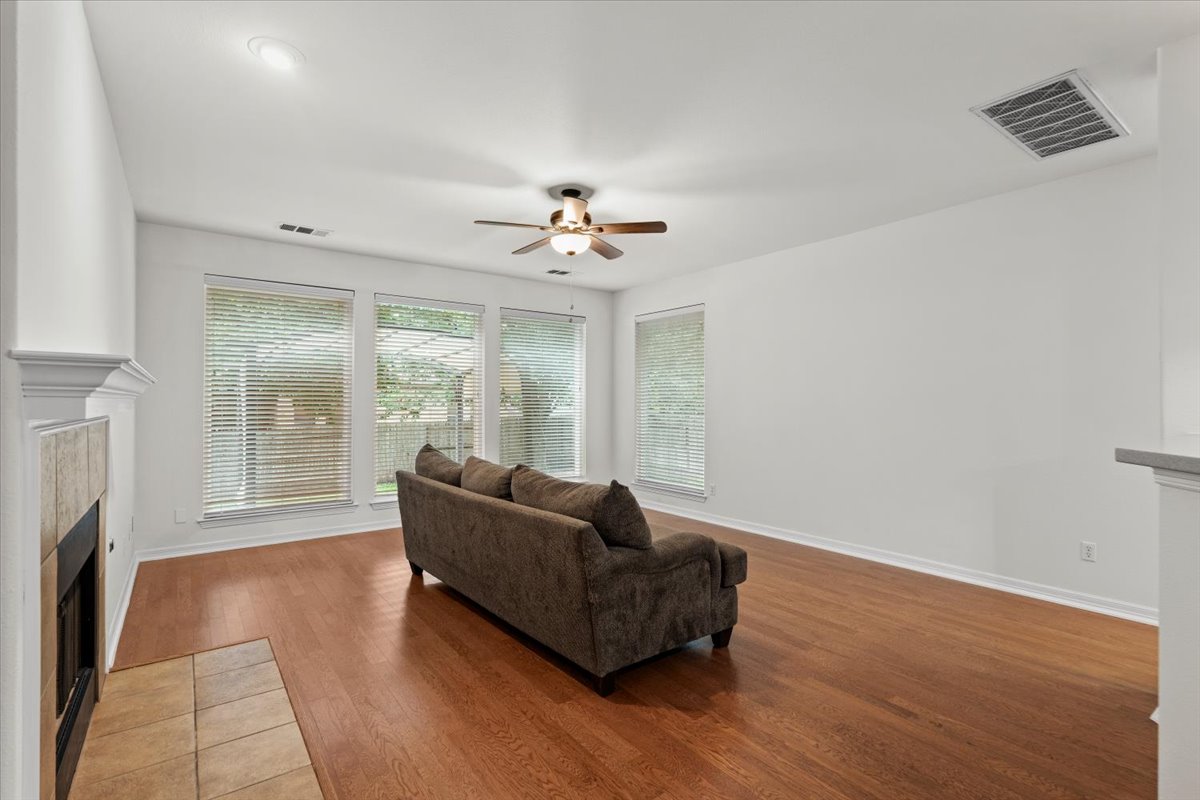 2304 Village View Loop Pflugerville, TX 78660 - Photo 15 of 40 Hardwood floors and a cozy fireplace provide comfort in this living room.