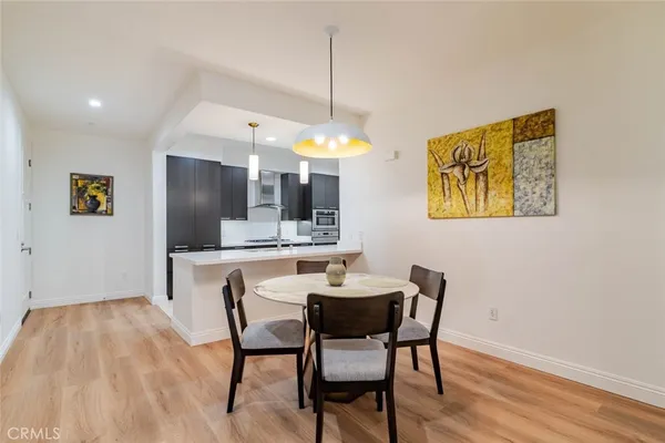 a kitchen with stainless steel appliances kitchen island granite countertop a dining table chairs and granite counter tops