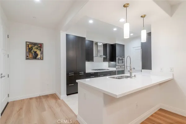 a kitchen with a sink a counter top space stainless steel appliances and cabinets
