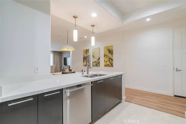 a kitchen with a sink dishwasher a stove and a refrigerator with wooden floor