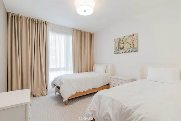 a bedroom with two beds and a large window