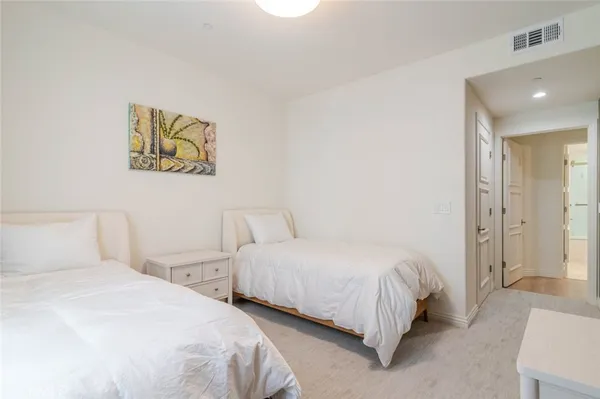 a bedroom with two beds and painting on the wall