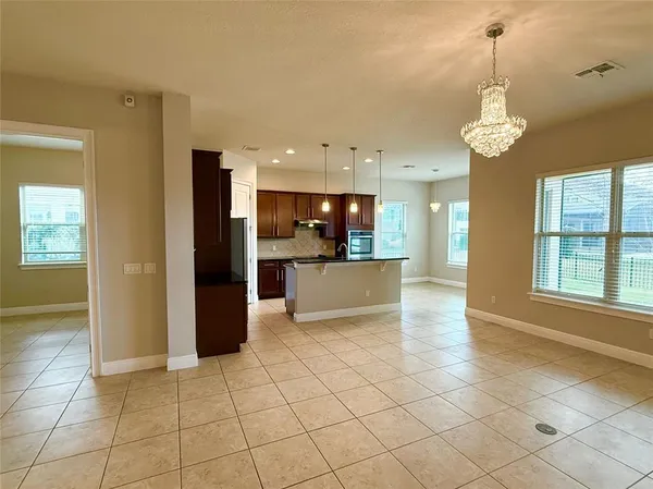 a view of a kitchen with kitchen island stainless steel appliances windows