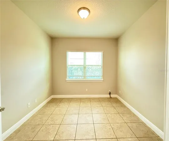 an empty room with wooden floor ceiling fan and windows
