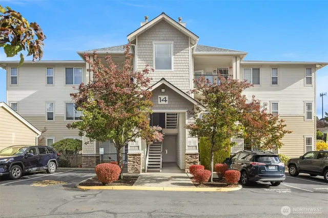 a front view of a house with a garden and parking