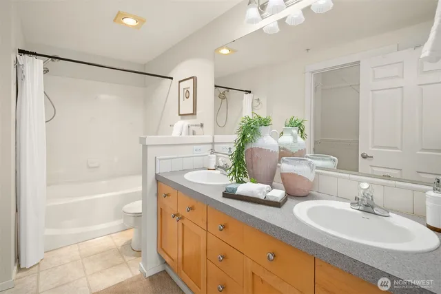a bathroom with a granite countertop sink mirror and a bathtub