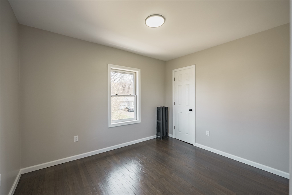 10 Bill Street Chicopee, MA 01013 - Photo 18 of 41 an empty room with wooden floor and windows