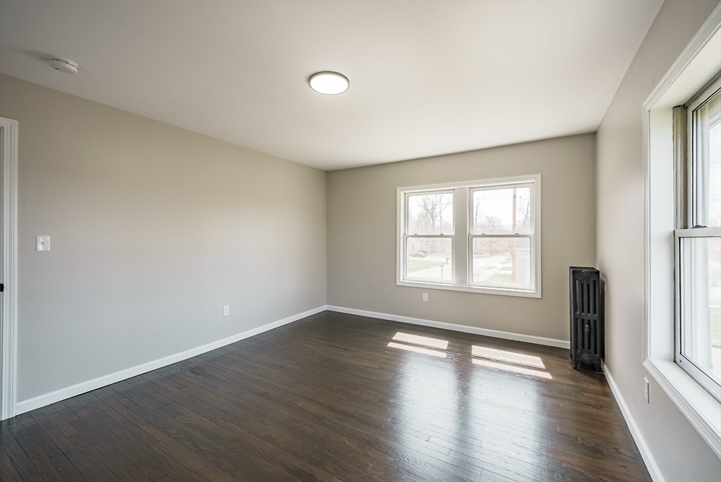 10 Bill Street Chicopee, MA 01013 - Photo 24 of 41 an empty room with wooden floor and windows