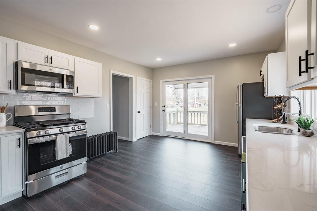 10 Bill Street Chicopee, MA 01013 - Photo 6 of 41 a kitchen with stainless steel appliances granite countertop a stove top oven a sink dishwasher a refrigerator and a microwave oven with wooden floor