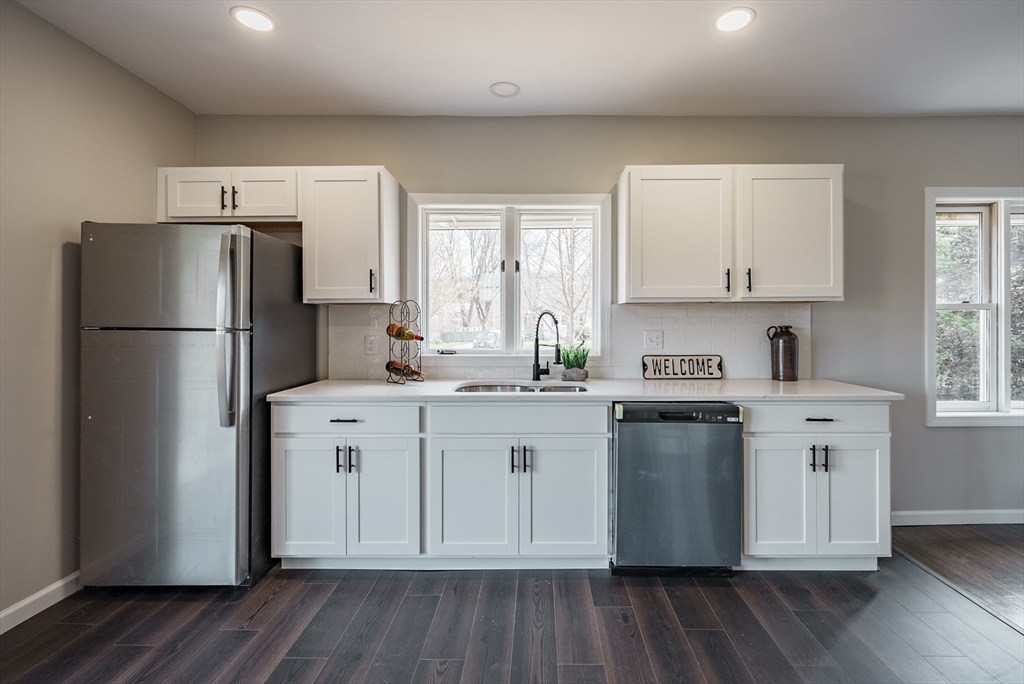 10 Bill Street Chicopee, MA 01013 - Photo 8 of 41 a kitchen with a refrigerator a sink dishwasher a stove and white cabinets with wooden floor