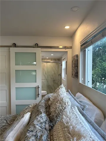 a bedroom with a bed and large window