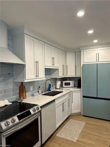 a kitchen with a sink appliances and cabinets