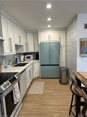 a kitchen with a refrigerator a stove a sink dishwasher and a stove with wooden floor