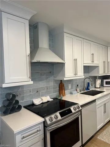 a kitchen with a stove and a white cabinets