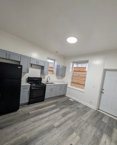 a kitchen with granite countertop a refrigerator stove and sink