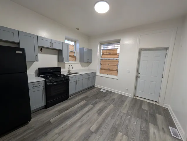 a kitchen with a refrigerator and a stove top oven
