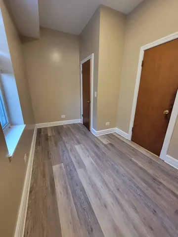 an empty room with wooden floor and entrance