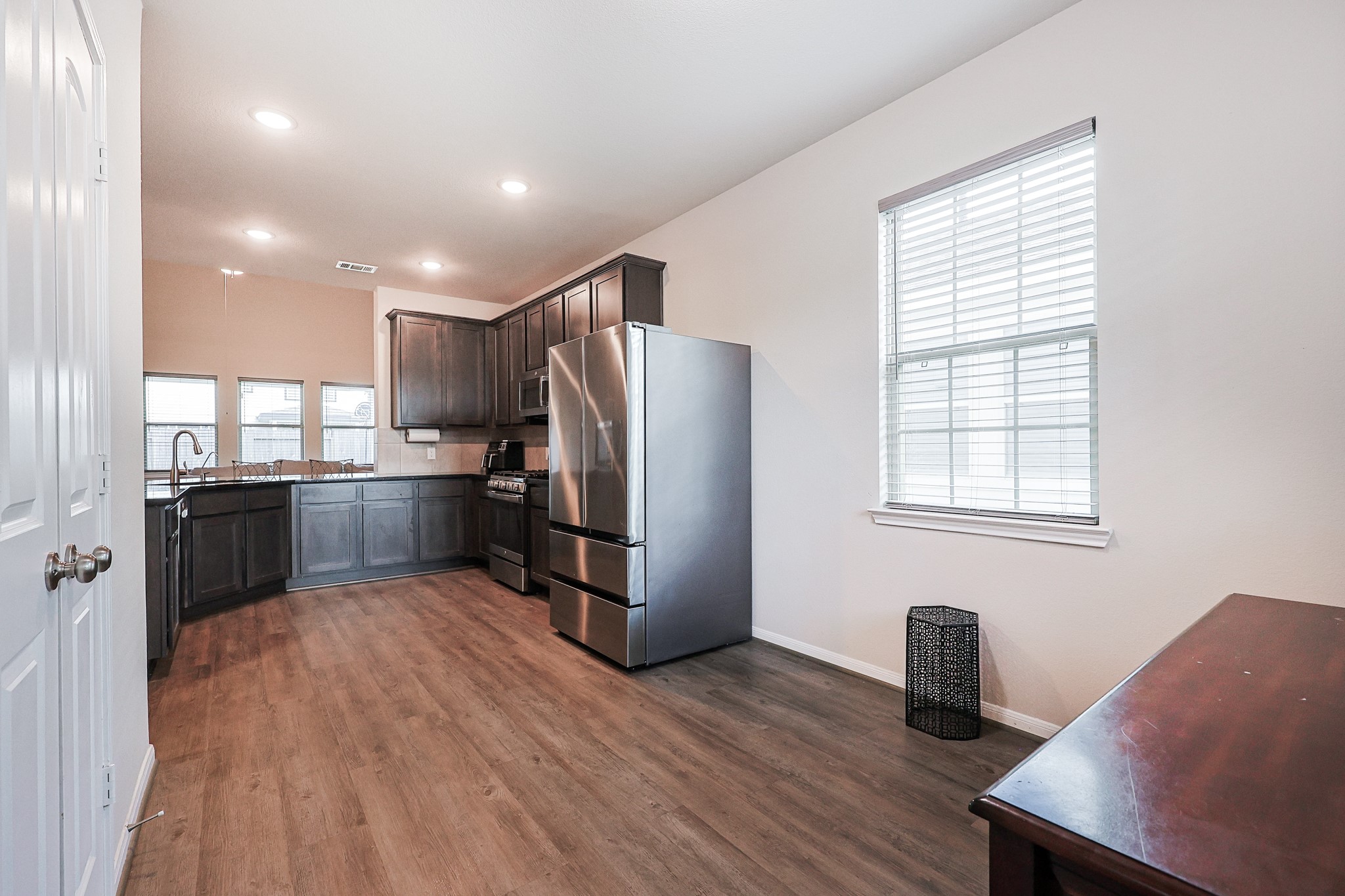 10423 Rochester Hls Lane Tomball, TX 77375 - Photo 16 of 36 This kitchen showcases the striking contrast between the rich dark cabinetry, polished countertops, and neutral walls.