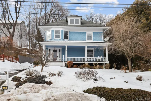 a front view of a house with a yard covered in snow
