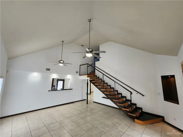 a view of a hallway with stairs and a chandelier