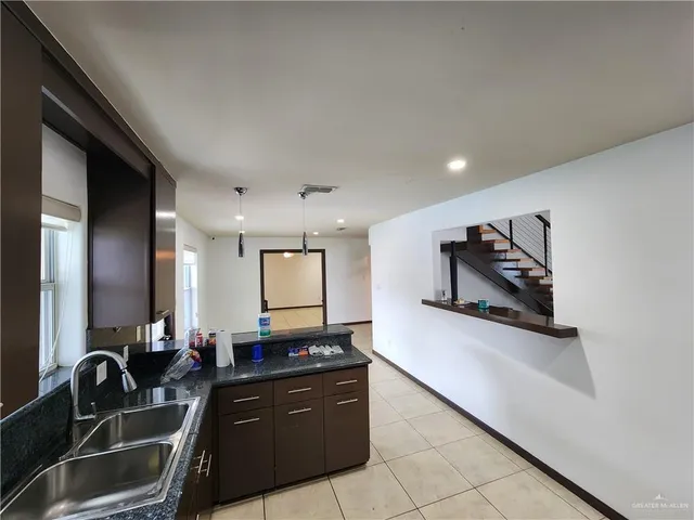 a kitchen with granite countertop a sink and a stove top oven with wooden floor