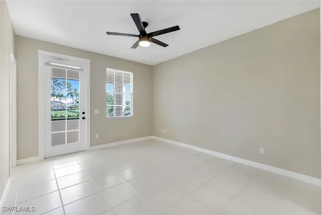 an empty room with windows and ceiling fan