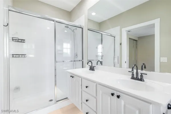 a bathroom with a shower sink vanity and mirror