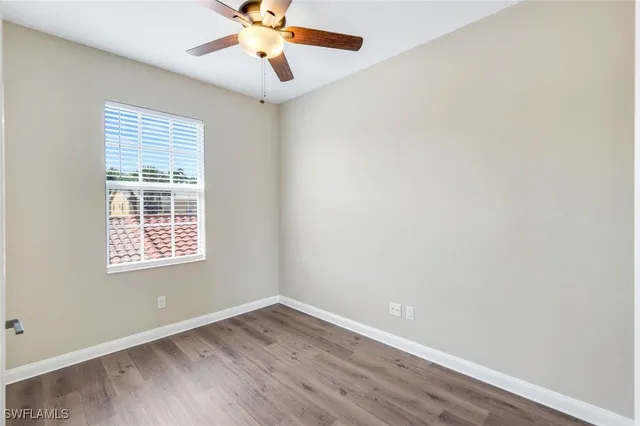 an empty room with a window and a fan