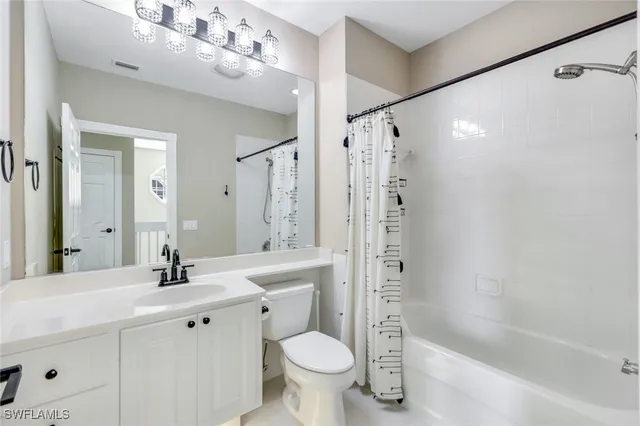 a bathroom with a sink a toilet a mirror a bathtub and shower