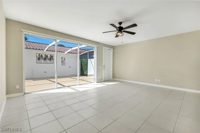 a view of a livingroom with a chandelier fan and windows