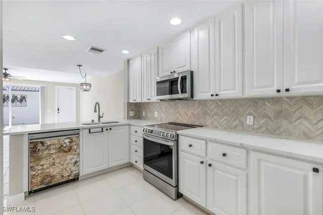 a kitchen with granite countertop white cabinets stainless steel appliances and sink