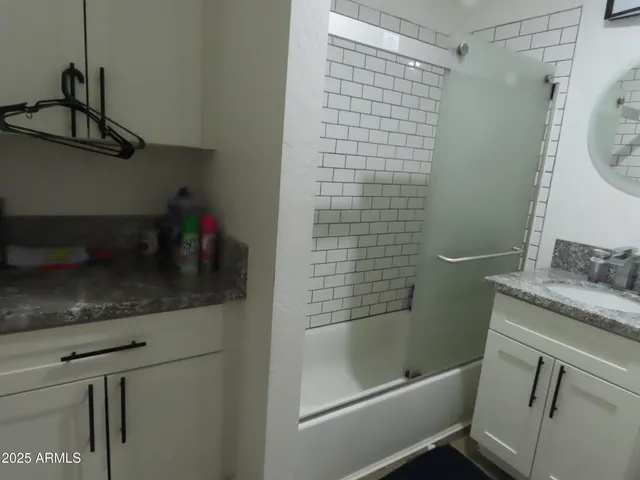 a bathroom with a granite countertop sink a toilet and shower