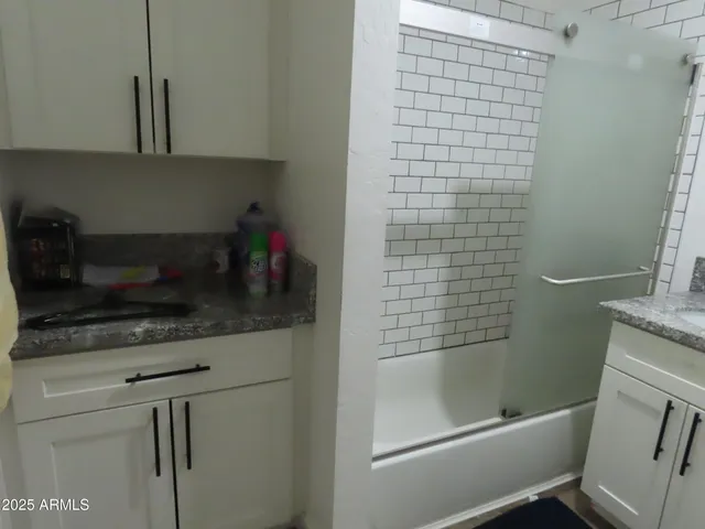 a bathroom with a granite countertop sink a toilet and shower