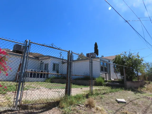 a view of a house with a yard and wooden fence